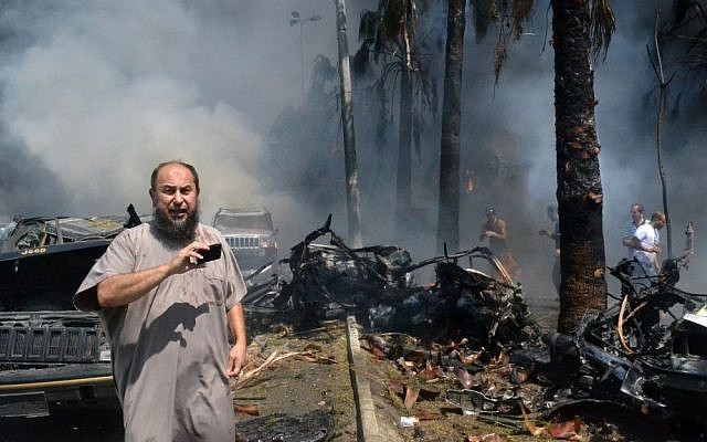 A Lebanese man takes pictures with his mobile phone at the site of an explosion outside a mosque in the northern city of Tripoli, Lebanon, on Friday (photo credit: AP) A Lebanese man takes pictures with his mobile phone at the site of an explosion outside a mosque in the northern city of Tripoli, Lebanon, on Friday (photo credit: AP)