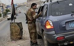 A Yemeni soldier inspects a car at a checkpoint on a street leading to the US embassy in Sanaa, Yemen, Sunday, Aug. 4, 2013. (Photo credit: AP/Hani Mohammed)