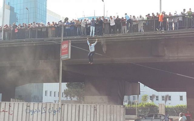 A man jumps off a bridge in Cairo to flee gunfire on Friday (photo credit: SarahCarr via Twitter)