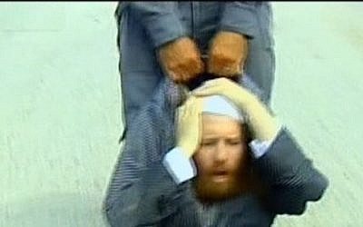 An ultra-Orthodox protester is dragged by a police officer at a construction site said to contain ancient Jewish graves, August 12, 2013 (photo credit: screen cap Channel 2 News) An ultra-Orthodox protester is dragged by a police officer at a construction site said to contain ancient Jewish graves, August 12, 2013 (photo credit: screen cap Channel 2 News)