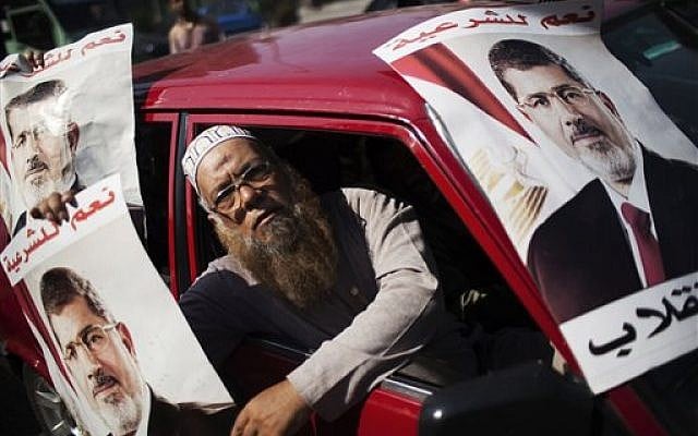 A supporter of Egypt's ousted President Mohammed Morsi holds a banner with Morsi's image, during a march against Egyptian Defense Minister Gen. Abdel-Fattah el-Sissi in the Nasr City section of Cairo, Friday, Aug. 2, 2013 (photo credit: AP Photo/Manu Brabo) A supporter of Egypt's ousted President Mohammed Morsi holds a banner with Morsi's image, during a march against Egyptian Defense Minister Gen. Abdel-Fattah el-Sissi in the Nasr City section of Cairo, Friday, Aug. 2, 2013 (photo credit: AP Photo/Manu Brabo)