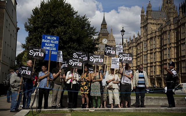 People take part in a protest calling for no military attack on Syria from the US, Britain or France, outside the Houses of Parliament, in London, on Thursday, August 29, 2013. (photo credit: AP/Matt Dunham) People take part in a protest calling for no military attack on Syria from the US, Britain or France, outside the Houses of Parliament, in London, on Thursday, August 29, 2013. (photo credit: AP/Matt Dunham)