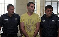 Aleksander Cvetkovic, center, a former Bosnian soldier suspected by Bosnian authorities of involvement in the killing of between 1,000 and 1,200 Bosnian Muslims in July 1995, is escorted by security officers before a hearing on his extradition to Bosnia, at the district court in Jerusalem, Monday, August 1, 2011 (photo credit: Kobi Gideon/Flash90)