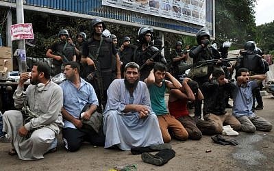 Egyptian security forces detain supporters of ousted Islamist President Mohammed Morsi  on Wednesday in Cairo. (photo credit: AP/Hussein Tallal)