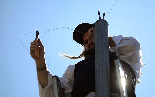 Illustrative photo of an ultra-Orthodox man hanging an eruv wire in the Gilo neighborhood of Jerusalem, Israel. (photo credit: Nati Shohat/Flash90/File) Illustrative photo of an ultra-Orthodox man hanging an eruv wire in the Gilo neighborhood of Jerusalem, Israel. (photo credit: Nati Shohat/Flash90/File)