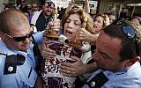 Police escort Anat Hoffman holding a Torah scroll from the Western Wall, on July 12, 2010. (Miriam Alster/Flash90)