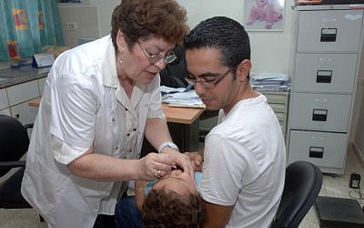 Take two drops and call me in the morning. An Israeli child receives the oral vaccination against polio in Beersheba in August 2013. (photo credit: Dudu Greenspan/FLASH90)