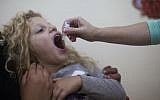 A child is inoculated with the oral polio vaccine at a children's health clinic in Jerusalem. (Yonatan Sindel/Flash90)