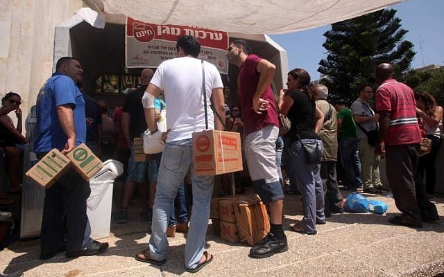 Israelis carry boxes with gas masks at a distribution center in Tel Aviv on August 28, 2013.(photo credit: Roni Schutzer/Flash90) Israelis carry boxes with gas masks at a distribution center in Tel Aviv on August 28, 2013.(photo credit: Roni Schutzer/Flash90)