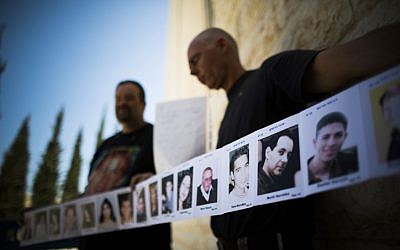 Relatives of Israelis killed in terror attacks holding signs as they demonstrate outside the Supreme Court in Jerusalem on August 11, 2013. (Photo credit: Yonatan Sindel/Flash90)