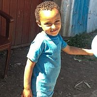 A young child leaves the synagogue with a smile on his face (photo credit: Michal Shmulovich/ToI)