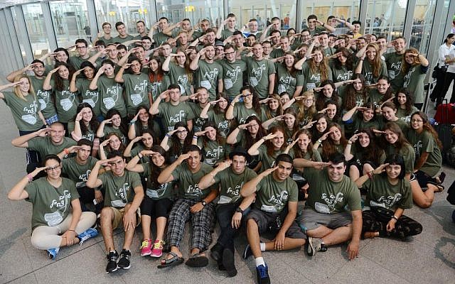 Members of the Garin Tzabar program saluting before their flight on Monday. (photo credit: Shahar Azran/Nefesh B'nefesh)