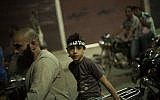 An Egyptian Muslim child rides on the back of a motorbike during a rally supporting former President Mohammed Morsi in Assiut, Upper Egypt, Tuesday, Aug. 6, 2013 (photo credit: AP/Manu Brabo)
