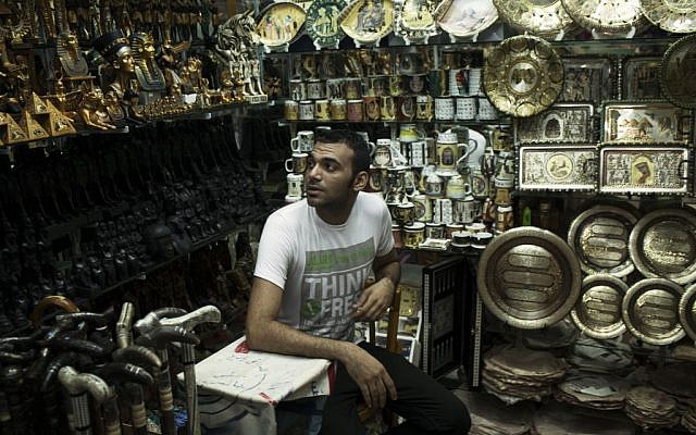 Romi, 26, waits for customers in his souvenir shop in the Khan El-Khalili market, normally a popular tourist destination, in Cairo, Egypt, Wednesday, August 21, 2013.(photo credit: AP Photo/Manu Brabo)