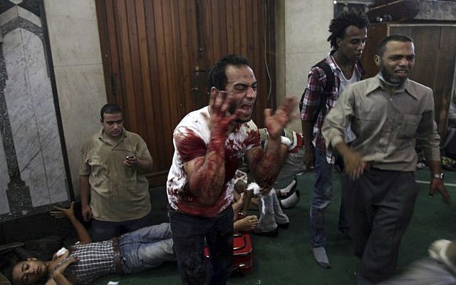 An Egyptian man covered with blood shouts inside the Al-Fath mosque that is being used as a makeshift hospital and is receiving casualties from clashes between security forces and supporters of Egypt's ousted President Mohammed Morsi in Ramses Square, downtown Cairo, Egypt, Friday, Aug. 16 (photo credit: AP) An Egyptian man covered with blood shouts inside the Al-Fath mosque that is being used as a makeshift hospital and is receiving casualties from clashes between security forces and supporters of Egypt's ousted President Mohammed Morsi in Ramses Square, downtown Cairo, Egypt, Friday, Aug. 16 (photo credit: AP)