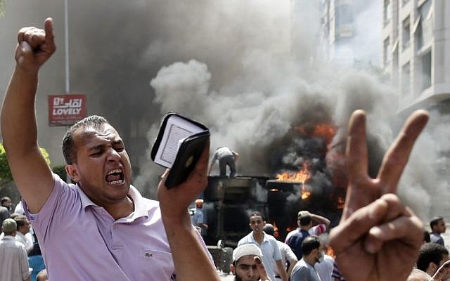 Supporters of Egypt's ousted president Mohammed Morsi chant slogans against Defense Minister Gen. Abdel-Fattah el-Sissi during clashes with Egyptian security forces in Cairo, Egypt, on Wednesday (photo credit: AP/Hassan Ammar) Supporters of Egypt's ousted president Mohammed Morsi chant slogans against Defense Minister Gen. Abdel-Fattah el-Sissi during clashes with Egyptian security forces in Cairo, Egypt, on Wednesday (photo credit: AP/Hassan Ammar)