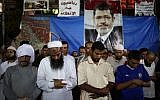Supporters of Egypt's ousted President Mohammed Morsi pray outside Rabaah al-Adawiya mosque, where supporters of Egypt's ousted President Mohammed Morsi have installed a camp and hold daily rallies at Nasr City, in Cairo, Egypt, late Tuesday, July 30, 2013 (photo credit: AP/Hassan Ammar)