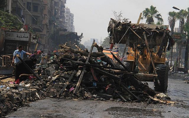 Soldiers clear debris as people sift through it the day after Egyptian security forces clear two encampments of supporters of ousted President Mohammed Morsi in Cairo's Nasr City on Thursday. (photo credit: AP/Ahmed Gomaa)