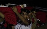 Egyptian military and policemen carry coffins, covered with national flags, containing the bodies of off-duty policemen who were killed near the border town of Rafah, North Sinai, upon their arrival at Almaza military airport, Cairo, Egypt, Monday, Aug. 19, 2013 (photo credit: AP/Khalil Hamra)