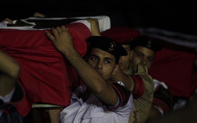 Egyptian military and policemen carry coffins, covered with national flags, containing the bodies of off-duty policemen who were killed near the border town of Rafah, North Sinai, upon their arrival at Almaza military airport, Cairo, Egypt, Monday, Aug. 19, 2013 (photo credit: AP/Khalil Hamra) Egyptian military and policemen carry coffins, covered with national flags, containing the bodies of off-duty policemen who were killed near the border town of Rafah, North Sinai, upon their arrival at Almaza military airport, Cairo, Egypt, Monday, Aug. 19, 2013 (photo credit: AP/Khalil Hamra)