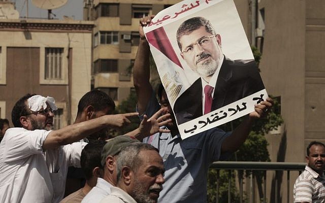 Supporters of ousted Egyptian president Mohammed Morsi, one holding his picture, cross the Nile as they march towards downtown Cairo from the Mohandeseen neighborhood of the city in August. (photo credit: AP Photo/Thomas Hartwell) Supporters of ousted Egyptian president Mohammed Morsi, one holding his picture, cross the Nile as they march towards downtown Cairo from the Mohandeseen neighborhood of the city in August. (photo credit: AP Photo/Thomas Hartwell)