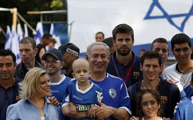 Prime Minister Benjamin Netanyahu, center, and his wife Sara, second left, pose for a picture with FC Barcelona players Xavi, far left, Gerard Pique, center right, and Lionel Messi, next to Pique, during a football event with young Israeli cancer patients near Tel Aviv, Israel, Sunday, Aug. 4, 2013 (photo credit: AP/Gali Tibbon, Pool)