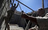 Palestinian men work at a construction site in the East Jerusalem neighborhood of Ramat Shlomo, May 4, 2010. (photo credit: AP/Tara Todras-Whitehill)