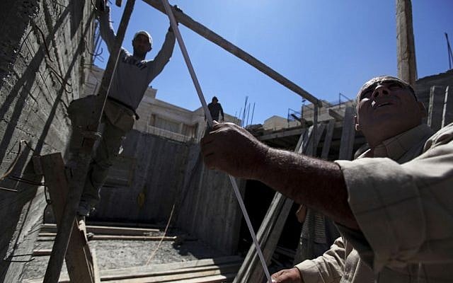 Palestinian men work at a construction site in the East Jerusalem neighborhood of Ramat Shlomo, May 4, 2010. (photo credit: AP/Tara Todras-Whitehill) Palestinian men work at a construction site in the East Jerusalem neighborhood of Ramat Shlomo, May 4, 2010. (photo credit: AP/Tara Todras-Whitehill)