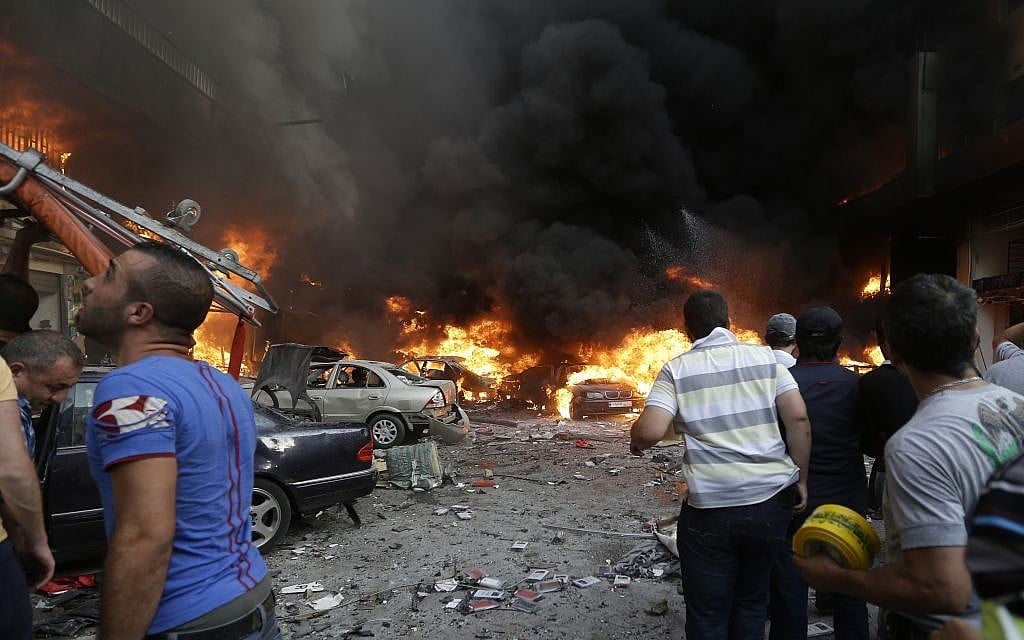 Lebanese citizens gather at the site of a car bomb explosion in southern Beirut, Lebanon, Thursday, Aug. 15, 2013. (Photo credit: AP /Hussein Malla)