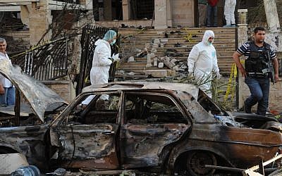 Lebanese army investigators inspect one of the explosion sites outside a mosque, in the northern city of Tripoli, Lebanon, on Friday. (photo credit: AP Photo/Ahmad Omar)