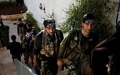 Illustrative photo of Syrian fighters of 'The Beloved of Allah' brigade hold their weapons before fighting with government forces on the outskirts of Aleppo, on November 14, 2012. (photo credit: AP/Khalil Hamra/File)