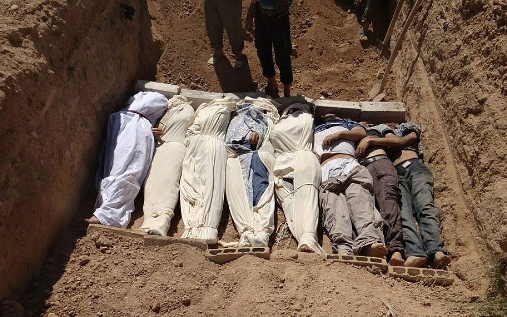 Bodies are buried after an August 21, 2013 chemical attack near Damascus (AP Photo/Shaam News Network)