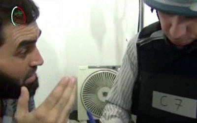 A UN inspector speaks to a victim of last week's chemical attack during a visit Monday to a makeshift hospital in Moadamiyeh, a suburb of the Syrian capital of Damascus. (photo credit: AP/Media Office Of Moadamiyeh)