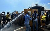 People try to protect themselves as riot and paramilitary police officers fire tear gas and use water cannons to disperse protesters outside the Silivri jail complex in Silivri, Turkey, Monday, Aug. 5, 2013 (photo credit: AP)