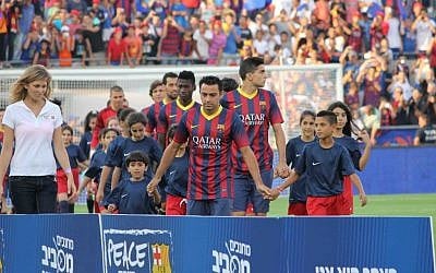 Xavi, center in jersey, escorting children onto the pitch for the pre-ceremony events. (photo credit: Yehuda Kirschenbaum) Xavi, center in jersey, escorting children onto the pitch for the pre-ceremony events. (photo credit: Yehuda Kirschenbaum)
