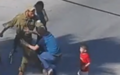 A soldier seen kicking a Palestinian boy in Hebron (photo credit: YouTube screen cap)