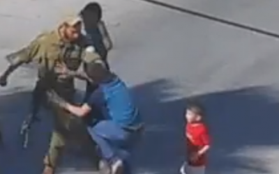 A soldier seen kicking a Palestinian boy in Hebron (photo credit: YouTube screen cap)
