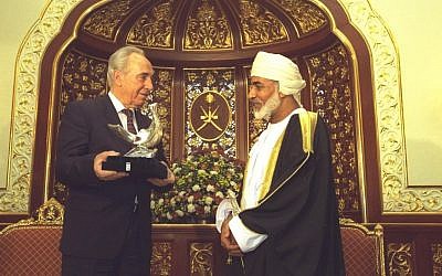 Then-prime minister Shimon Peres presents a sculpture of the dove of peace to Omani Sultan Qaboos bin Said El Said in the palace in Salala, April 1, 1996. (Avi Ohayun/GPO)