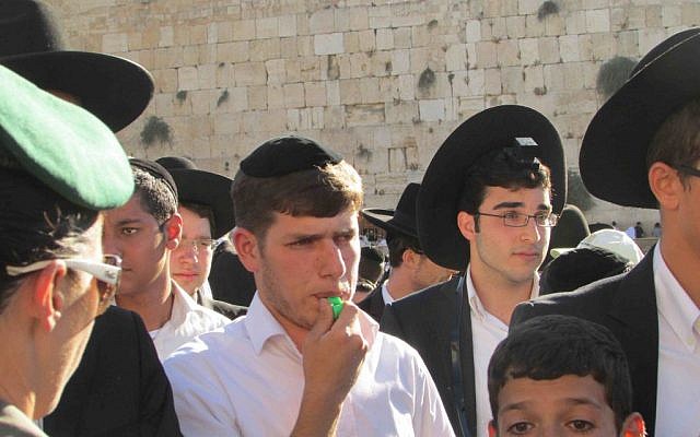 Male protesters blowing whistles to drown out the sound of women's singing. (photo credit: Debra Kamin/Times of Israel)