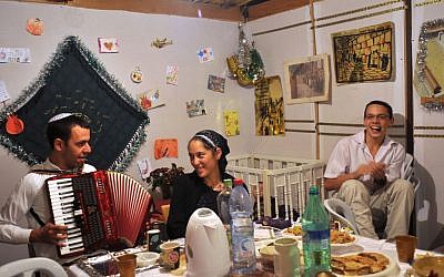 Israeli family eating in the sukkah during the second night of Sukkot in the Jewish quarter in the Old City of Jerusalem. (photo credit: Serge Attal / Flash 90)