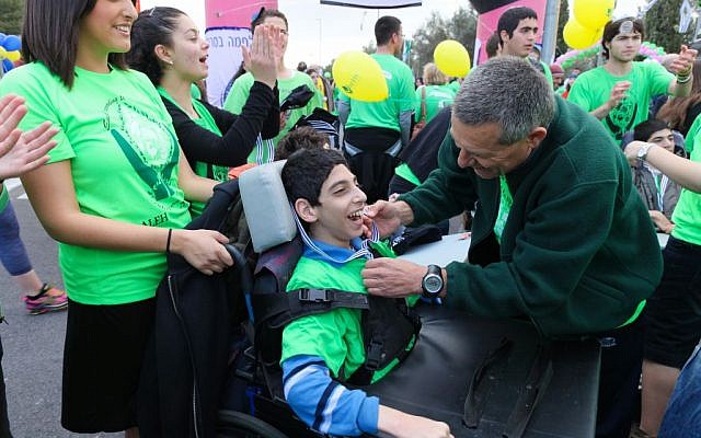 Doron Almog puts a medal on a child from ALEH Jerusalem child at the Jerusalem Marathon. (photo credit: courtesy Aleh) Doron Almog puts a medal on a child from ALEH Jerusalem child at the Jerusalem Marathon. (photo credit: courtesy Aleh)
