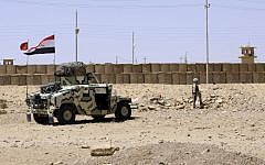An Iraqi soldier stands guard in Qaim, near the Syrian border, in the Euphrates river valley 200 miles (320 kilometers) west of Baghdad, Iraq. (photo credit: AP Photo/Khalid Mohammed)
