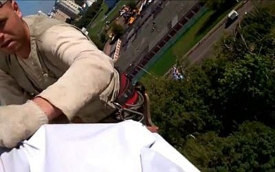 City-hired climbers removing election banners of Alexei Navalny in Moscow, August 2013. (photo credit: YouTube/JTA)