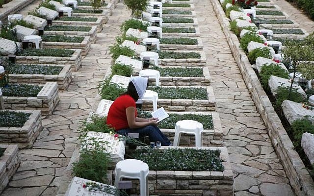 A woman sits next to the grave of fallen soldier from the 1973 Yom Kippur War, in the Mount Herzl military cemetery in Jerusalem (Michal Fattal/Flash90) A woman sits next to the grave of fallen soldier from the 1973 Yom Kippur War, in the Mount Herzl military cemetery in Jerusalem (Michal Fattal/Flash90)