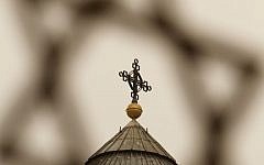 Illustrative photo of a cross seen through a Star of David in the Old City of Jerusalem. (photo credit: Miriam Alster/Flash90)