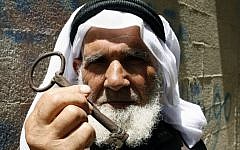 A Palestinian refugee holds up a key allegedly from his house in Beersheba, in southern Israel, during a rally in Rafah, Gaza Strip, May 2013 (photo credit: Abed Rahim Khatib/Flash90)