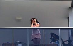 A shocked neighbor observes the murder scene in Tel Aviv, where 52-year-old Eli Gur killed his two children before committing suicide, on Thursday, September 19, 2013. (photo credit: Roni Schutzer/Flash90)