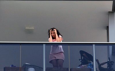 A shocked neighbor observes the murder scene in Tel Aviv, where 52-year-old Eli Gur killed his two children before committing suicide, on Thursday, September 19, 2013. (photo credit: Roni Schutzer/Flash90)