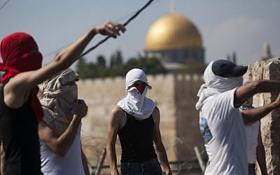 Palestinians hurl stones at Israeli police officers (unseen) in East Jerusalem (photo credit: Yonatan Sindel/Flash90)