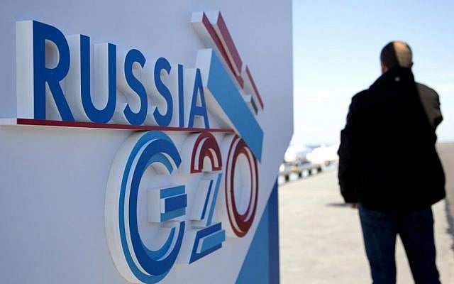 A journalist speaks on a cell phone next to a sign for the G-20 summit in St. Petersburg, Russia on Wednesday, September 4, 2013. (AP/Virginia Mayo) A journalist speaks on a cell phone next to a sign for the G-20 summit in St. Petersburg, Russia on Wednesday, September 4, 2013. (AP/Virginia Mayo)